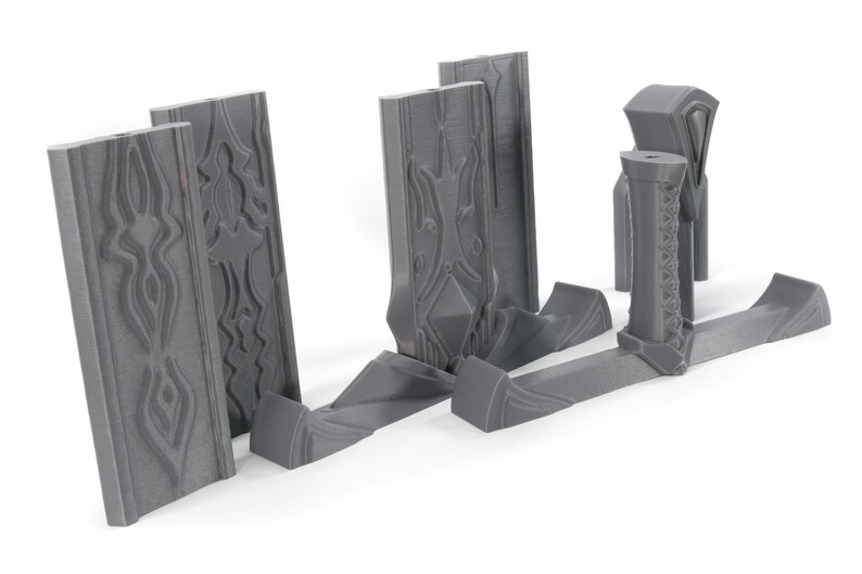 May include: A set of gray plastic pieces for building a miniature castle wall. The pieces have intricate designs and are ready to be assembled.