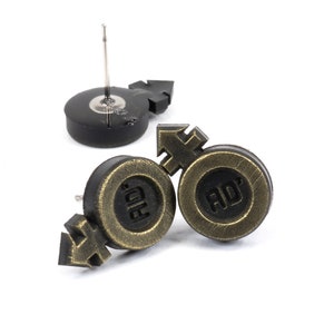 May include: A pair of gold-toned earrings with black accents. Each earring features a stylized gender symbol and the letters "RD" in a circle.