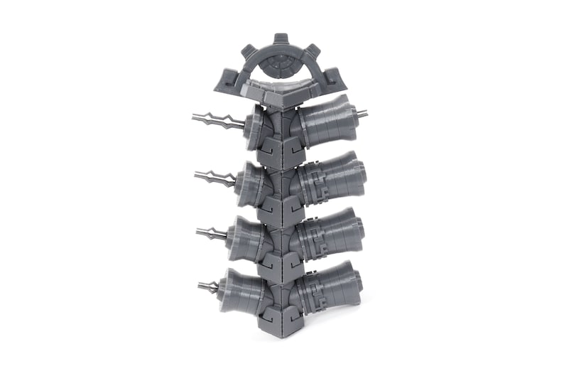 May include: A gray plastic storage rack with five slots for holding small tools or other items. The rack is designed to be stacked on top of other racks.