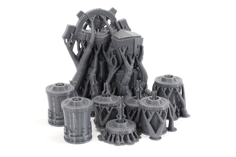 May include: A set of 3D printed gray plastic miniature buildings with intricate details. The buildings are designed with a futuristic, sci-fi aesthetic.
