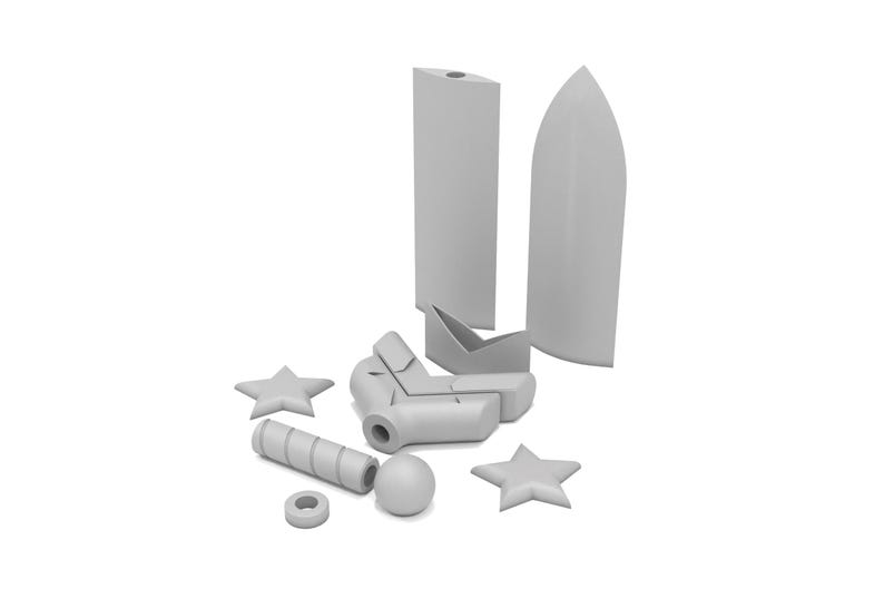 May include: An assortment of gray, geometric shapes, including two star shapes, a cylinder, a sphere, a ring, and several angular forms. The objects are arranged on a white background, suggesting a design or architectural theme.