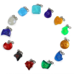 May include: A set of 12 colorful keychains with different symbols. Each keychain is made of a translucent plastic material and features a silver metal ring.