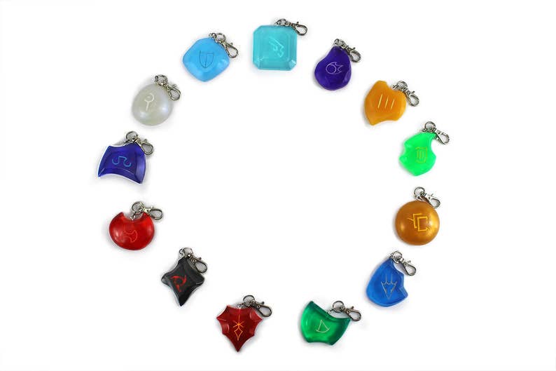 May include: A set of 12 colorful keychains with different symbols. Each keychain is made of a translucent plastic material and features a silver metal ring.