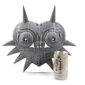 May include: A gray, heart-shaped mask with spikes and a textured surface. The mask is about the size of a can of soda.