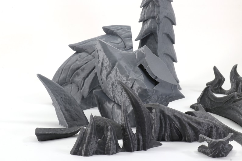 May include: A set of gray 3D printed dragon scales, claws, and tail pieces. The pieces are designed to be assembled into a larger dragon sculpture.