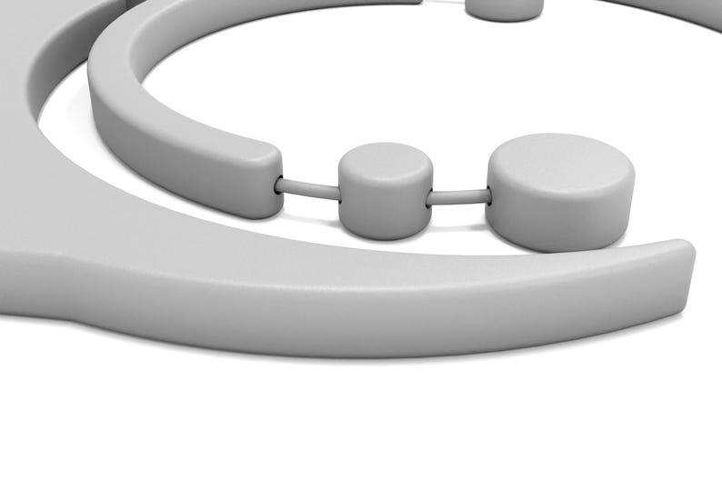 May include: A close-up of a light gray, abstract sculpture with rounded shapes. The sculpture has a curved, semi-circular element and several cylindrical components connected by thin rods. The design is minimalist and modern, set against a white background.