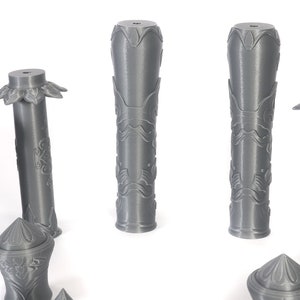 May include: A set of six gray 3D printed decorative columns with intricate designs. The columns are various sizes and shapes, with some having a flared top and others having a flat top.
