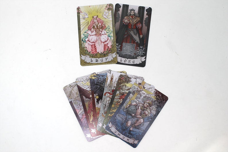 May include: A set of tarot cards featuring illustrations of people and scenes. The cards are in a variety of colors, including gold, silver, and black. The cards are arranged in a fan shape, with the top card showing a woman in a pink dress. The text on the cards includes the words "Lord" and "Cup".