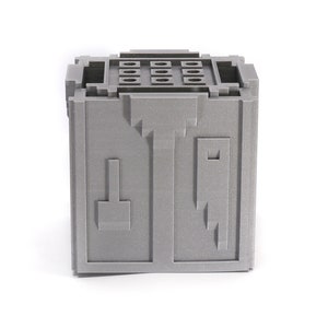 May include: A gray, cube-shaped storage box with a textured surface and a series of small holes on the top. The box has a unique design with geometric shapes on the front.