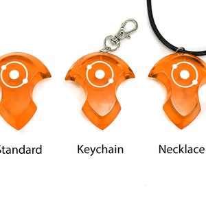 May include: Three orange plastic pendants with a white atom symbol. The pendants are shown in three different styles: standard, keychain, and necklace.