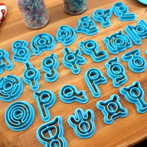 May include: A set of 20 blue plastic cookie cutters shaped like different geometric designs.