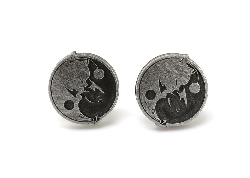 May include: A pair of silver cufflinks with a yin yang design featuring two stylized dragons facing each other.