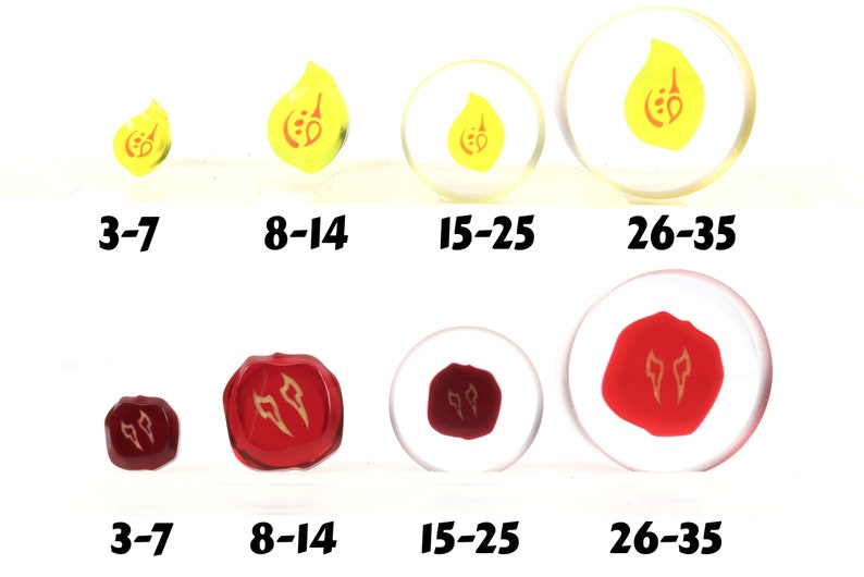 May include: Four sets of dice with different sizes. The dice are yellow with a red symbol and red with a gold symbol. The dice are labeled with numbers 3-7, 8-14, 15-25, and 26-35.