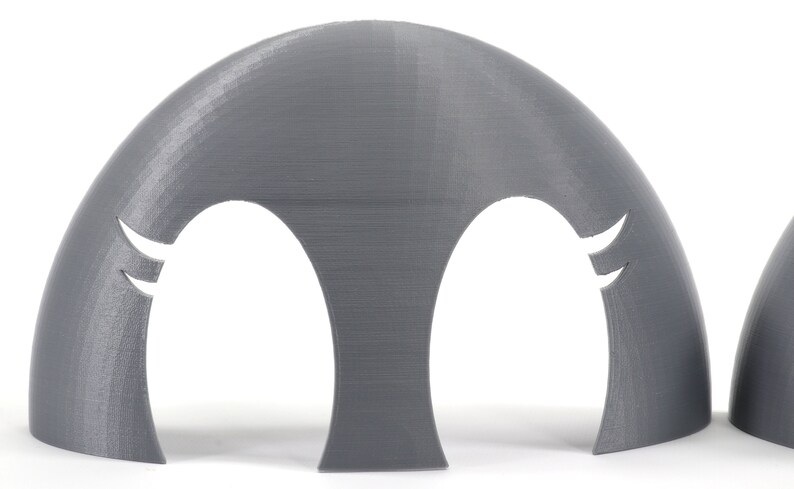 May include: A pair of gray plastic molds with two cut-out shapes. The molds are designed to create a three-dimensional object.