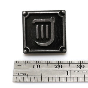 Op de afbeelding: Een zilveren metalen pin met een zwarte achtergrond en een zilveren harp symbool. De pin is ongeveer 2 cm breed.