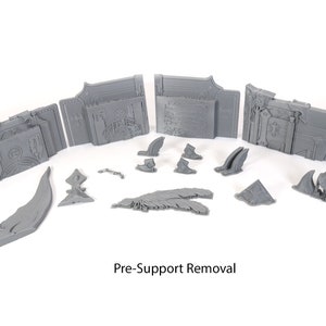May include: A set of gray 3D printed pieces for a tabletop game or miniature. The pieces are in various shapes and sizes, including a large, ornate archway, a smaller archway, and several smaller pieces. The pieces are pre-support removal, meaning they have not yet been cleaned up after printing.