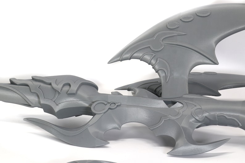 Peut inclure: Mod&egrave;le d'arme fantastique imprim&eacute; en 3D en plastique gris avec des d&eacute;tails complexes. L'arme est compos&eacute;e de plusieurs pi&egrave;ces, dont une lame, une poign&eacute;e et une pi&egrave;ce d&eacute;corative.