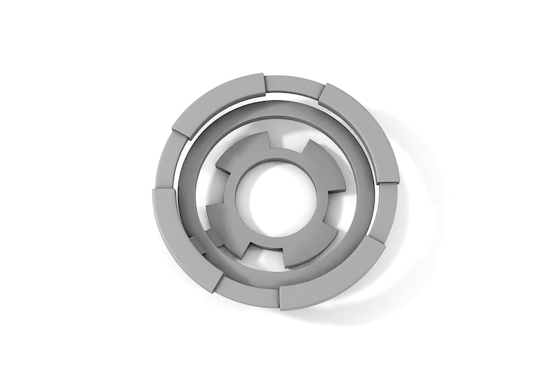 May include: A gray, circular, geometric design with concentric rings and a central starburst shape.