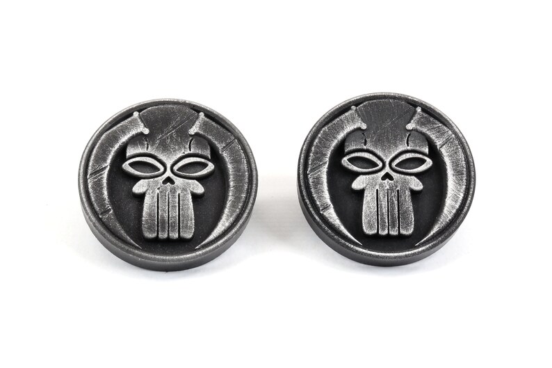 May include: Two silver-toned metal cufflinks featuring a skull design with horns. The skull has a detailed design with a textured surface.