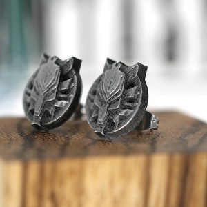 Op de afbeelding: Een paar zilveren oorbel studs met een gedetailleerd wolfskop ontwerp.