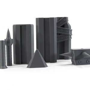 May include: A set of six grey 3D printed objects, including a pyramid, two spiky towers, a rectangular block, a tall rectangular block with a textured surface, and a spiky anvil.