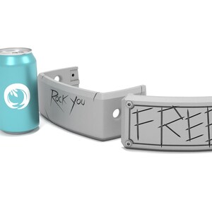 May include: A teal soda can with a white logo and two gray, curved, sign-like objects. One sign reads "Rock You" and the other reads "FREE". The objects are gray with black lines.