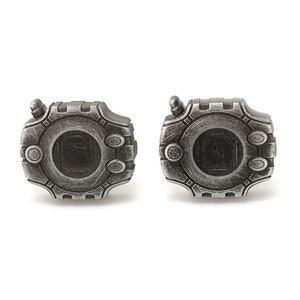 May include: A pair of silver cufflinks shaped like a digital watch with a black screen. The cufflinks have a detailed design with a textured surface.