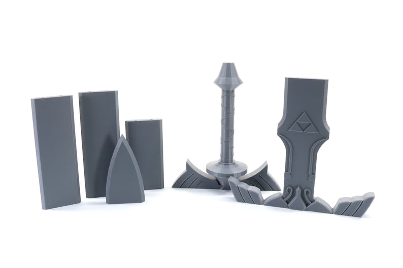 Puede incluir: Un modelo de pl&aacute;stico gris de la Espada Maestra del videojuego The Legend of Zelda. La espada est&aacute; desmontada en varias piezas, incluyendo la hoja, la empu&ntilde;adura y la guarda.