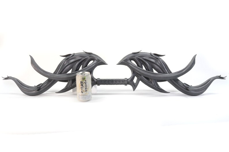 May include: A gray, intricately designed, double-ended weapon with a long, thin handle. The weapon is about the size of a standard aluminum can.