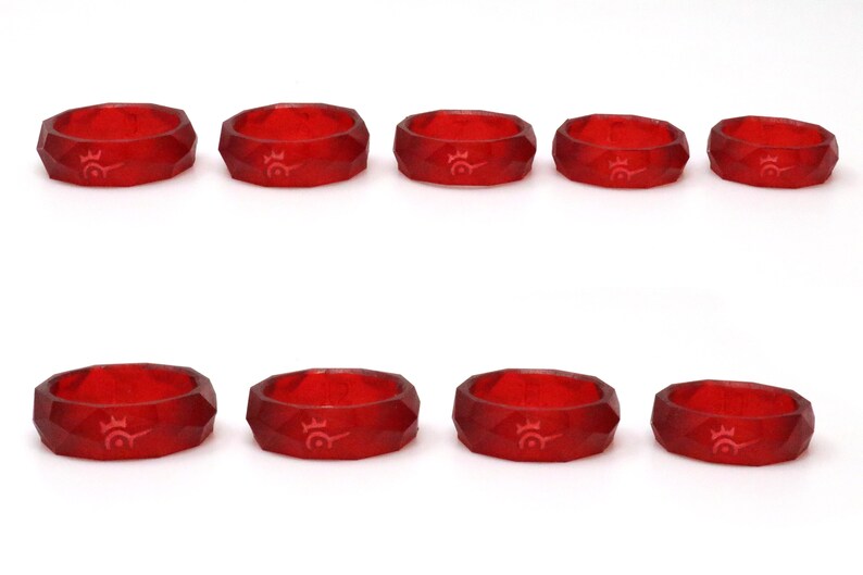 May include: Eight red, faceted rings with a white logo design. The rings are arranged in two rows of four.