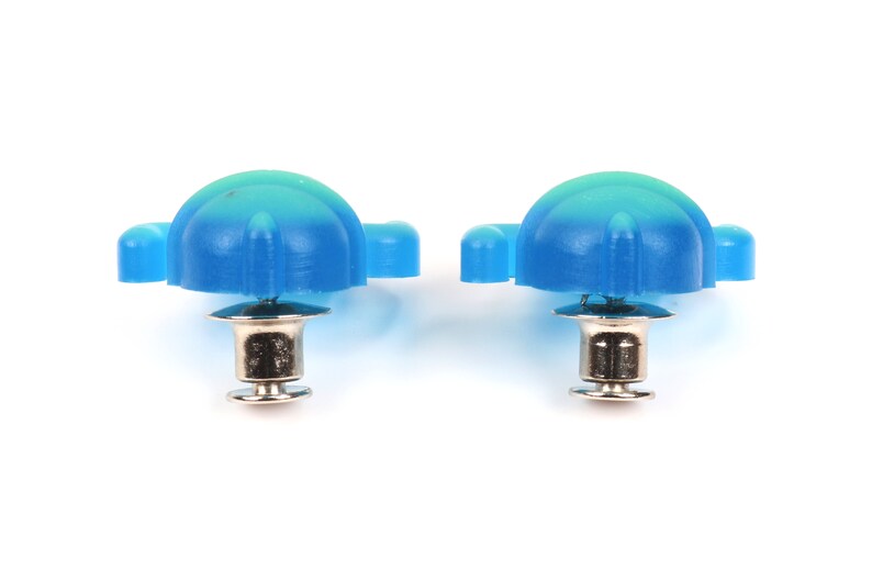 May include: Two blue plastic shoe eyelets with silver metal posts. The eyelets have a rounded top and a flat bottom.