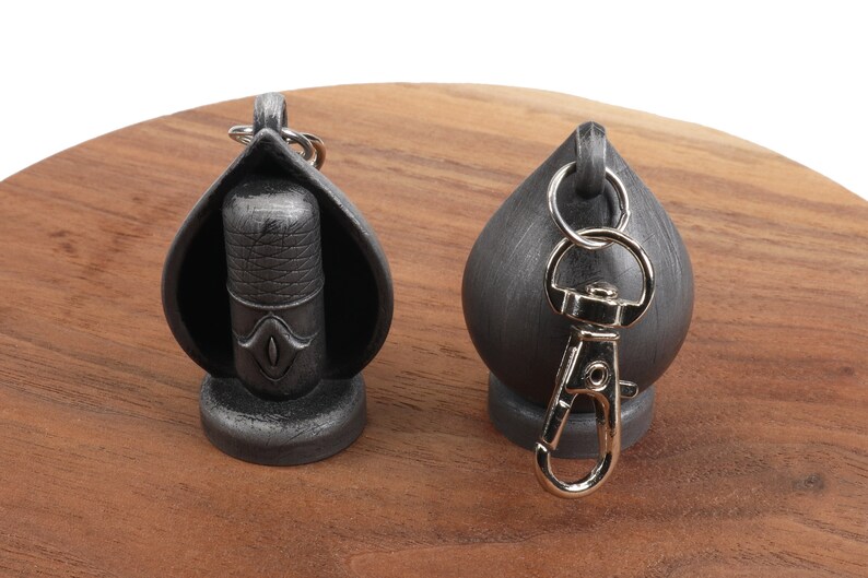 May include: Two silver keychains, one with a microphone design and the other with a round shape. Both keychains have a silver metal ring.