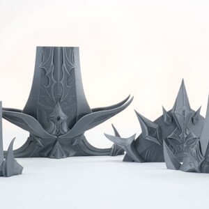 Puede incluir: Un conjunto de cinco piezas impresas en 3D de color gris con dise&ntilde;os intrincados. Las piezas est&aacute;n hechas de un pl&aacute;stico liso y mate y tienen una variedad de formas y tama&ntilde;os. Las piezas est&aacute;n dise&ntilde;adas para ser utilizadas como elementos decorativos o como parte de un proyecto m&aacute;s grande.