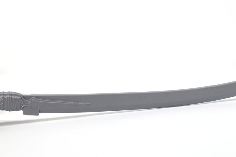 May include: A gray metal sword with a curved blade and a detailed hilt.
