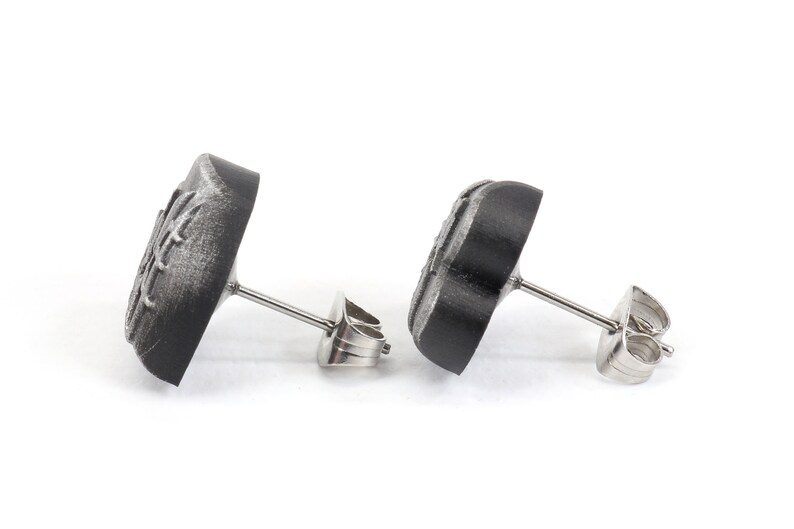 May include: A pair of black stud earrings with a silver post and butterfly design.