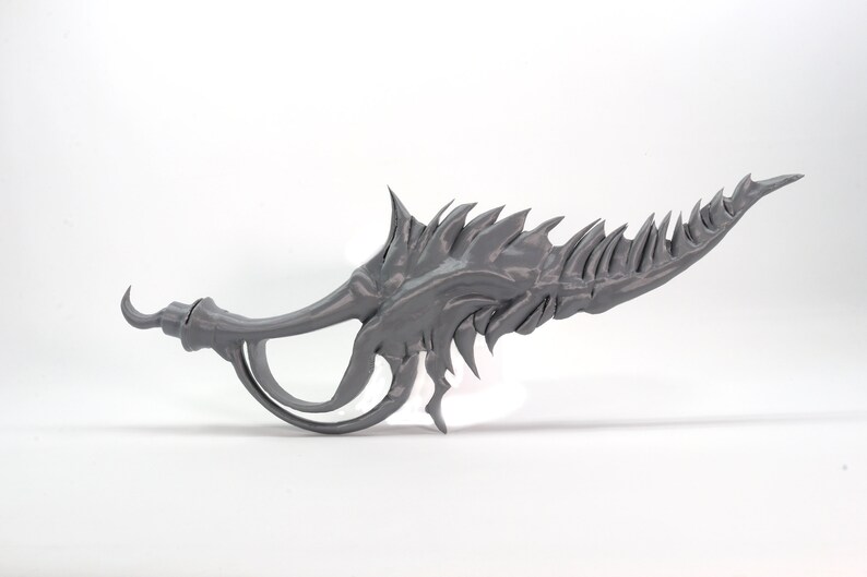 May include: A gray 3D printed weapon with a sharp, jagged blade and a curved handle.