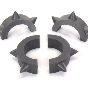 May include: Three grey plastic rings with spikes. The rings are designed to be connected together to form a larger ring.