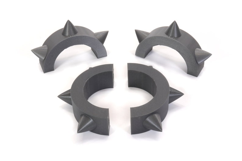 May include: Three grey plastic rings with spikes. The rings are designed to be connected together to form a larger ring.