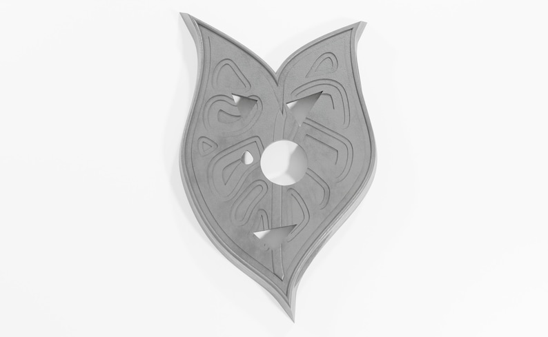 May include: A gray, heart-shaped, decorative wall hanging with a carved design. The design features a circle in the center and intricate patterns around it.