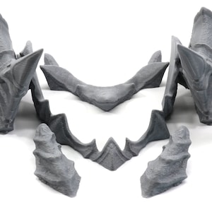 May include: A set of six grey 3D printed pieces that can be assembled to create a dragon head sculpture.
