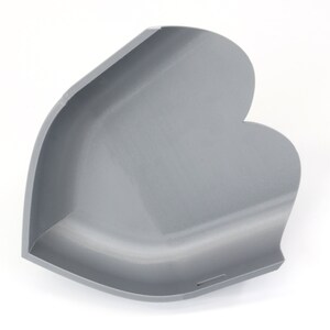 May include: A gray, heart-shaped corner shelf, likely for decorative or storage purposes. The shelf has a smooth, matte finish and a curved design. The product is made of a solid material and is set against a white background.