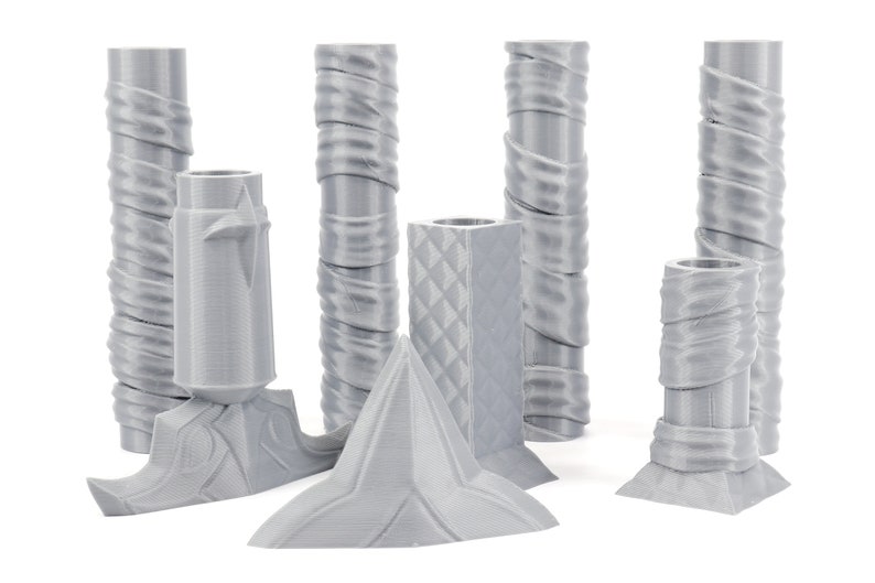 Puede incluir: Un conjunto de siete candelabros grises impresos en 3D con diferentes dise&ntilde;os. Los candelabros est&aacute;n hechos de un pl&aacute;stico liso y mate y tienen una variedad de formas geom&eacute;tricas.