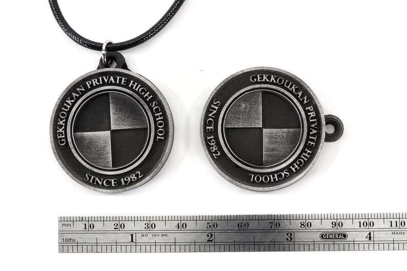 May include: A silver pendant necklace with a round charm featuring the words "Gekkoukan Private High School Since 1982" and a black and white checkered design.