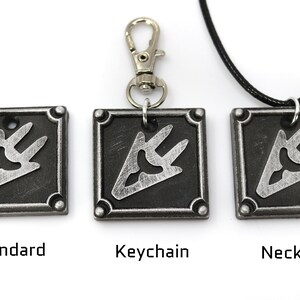 May include: Three silver metal pendants with a black and silver design. The pendants are shown in three different styles: standard, keychain, and necklace.