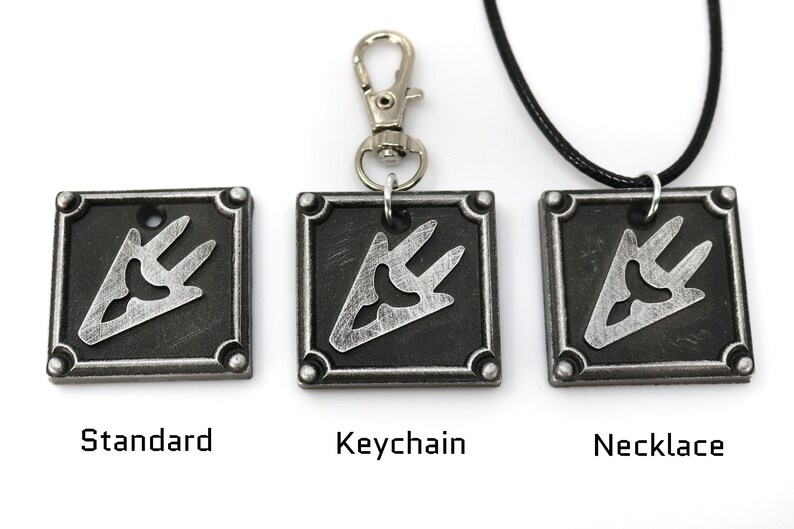 May include: Three silver metal pendants with a black and silver design. The pendants are shown in three different styles: standard, keychain, and necklace.