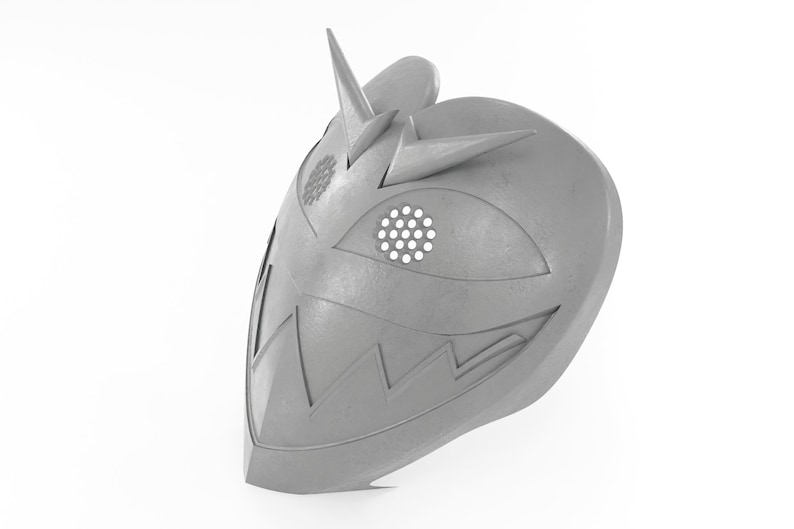 May include: A gray, metallic mask with a sharp, pointed design. The mask has a large, open eye hole with a circular pattern and a jagged, toothy mouth.
