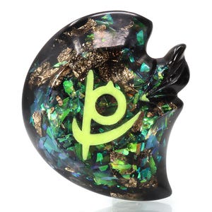 May include: A black resin pendant with a green and gold glitter design and a glowing green symbol in the center.