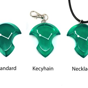 May include: Three green resin pendants with a white constellation design. One is a standard pendant, one is a keychain, and the third is a necklace. The word "Standard", "Keychain", and "Necklace" are printed below each pendant.