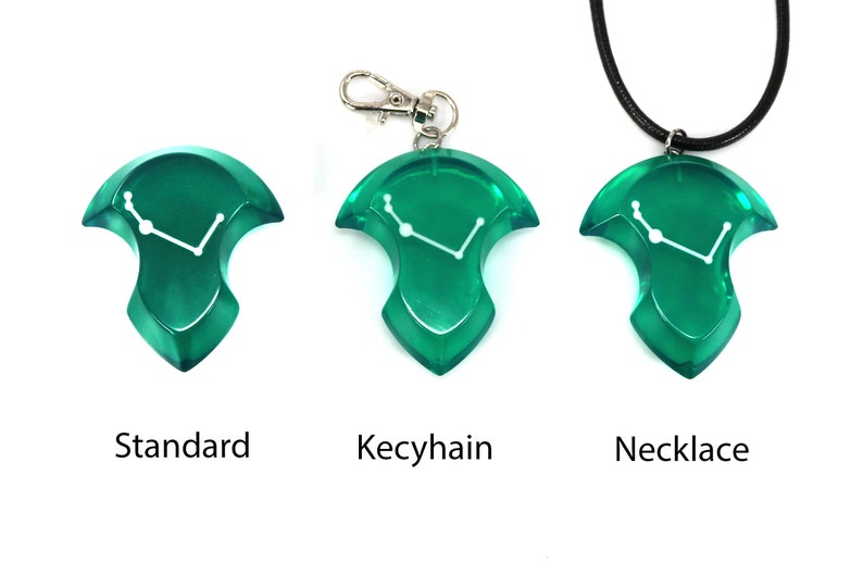 May include: Three green resin pendants with a white constellation design. One is a standard pendant, one is a keychain, and the third is a necklace. The word "Standard", "Keychain", and "Necklace" are printed below each pendant.