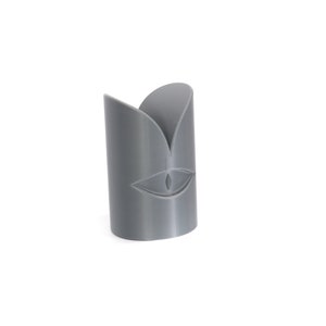May include: A grey 3D printed candle holder with a stylised eye design.